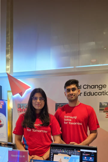 Aadish Abhijeet Shelke and Bhagyashri Heeralal Meena, co-founders of NextPlayAI, are being photographed at the company’s exhibition booth.