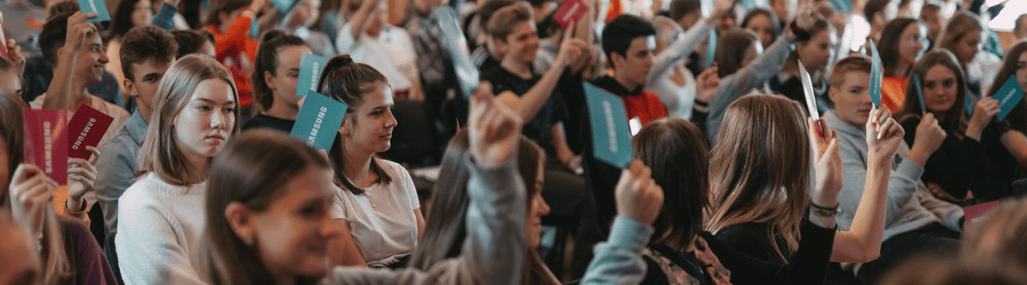 Youth holding a paper with 'SAMSUNG' written on it