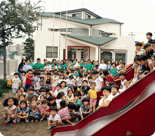 Children at Samsung Daycare Center are gathering together in the playground to take a commemorative photo