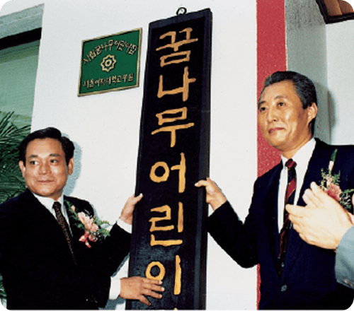Chairman Lee Kun-hee of Samsung and Mayor Go Geon of Seoul City are taking a commemorative photo at the unveiling ceremony of 'Dreamtree Daycare Center'