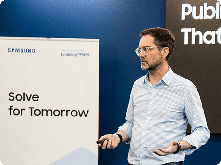 A lecturer is giving a presentation in front of students participating in Samsung Solve for Tomorrow.