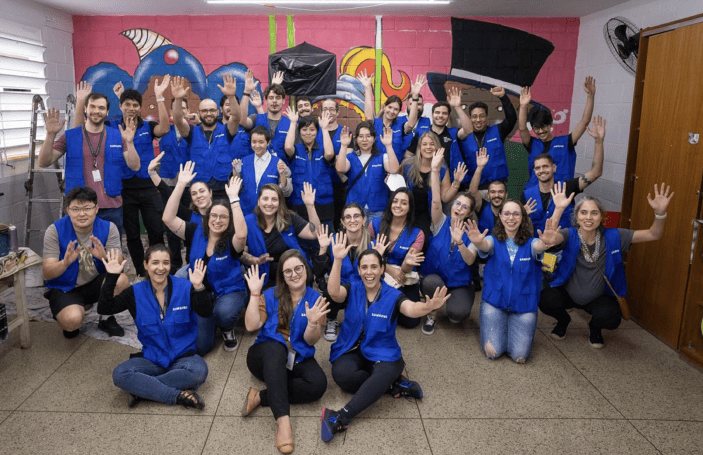 Samsung employees in Latin America are visiting a child welfare institution after volunteering and taking a group photo together.